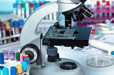 laboratory microscope with a blood sample on the slide / laboratory work table with a microscope and blood samples