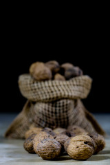 Fresh nuts in a jute bag on a wooden kitchen table. Italian hazelnuts in the kitchen before Christmas.