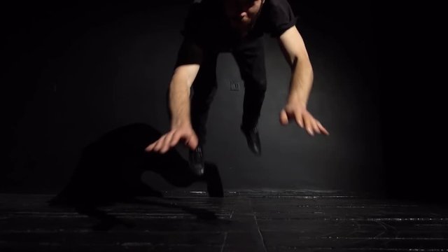 Guy breakdancer looks at the camera and jumps forward