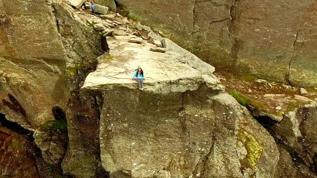 Trolltunga. Norway. girl sitting on the edge of the Trolltunga. aerial vie. beautiful landscape of Norway