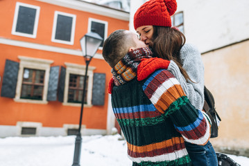 Young couple in love kissing at winter day in the old city