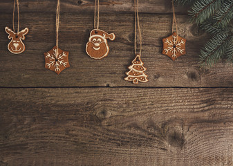 Gingerbread cookies hanging over wooden background. Space for text