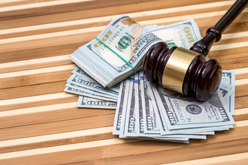 wooden gavel with dollar banknote on desk