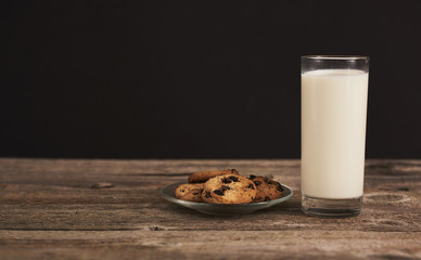 chocolate cookies for Santa and glass of milk on wood board