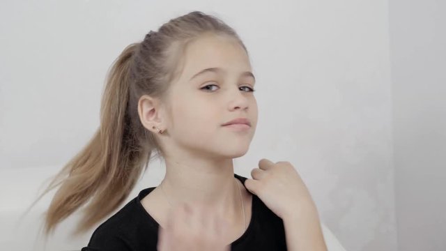 happy little cute girl woke up in white bed, smiling kid child model face pretty beautiful schoolgirl