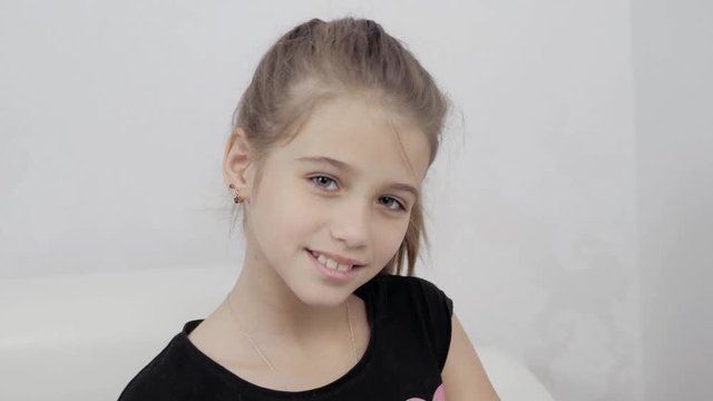 happy little cute girl woke up in white bed, smiling kid child model face pretty beautiful schoolgirl
