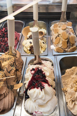 Creamy italian ice-cream in shop window, displayed in metal tubes. Ice cream parlor 