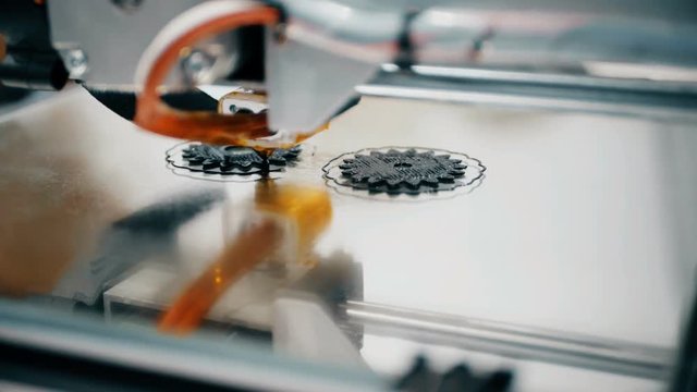 3D diy printer printing plastic mechanical parts in timelapse.An open source diy 3d printer is printing gears and pulleys,using disposable biodegreadable PLA material. Plastic model on a 3D printer