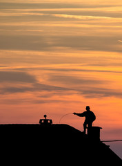 Chimney Sweep on Roof - silhouette