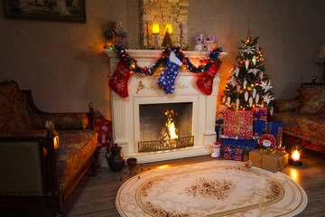 Christmas decorations and gifts in the living room with a burning fireplace and a Christmas tree.