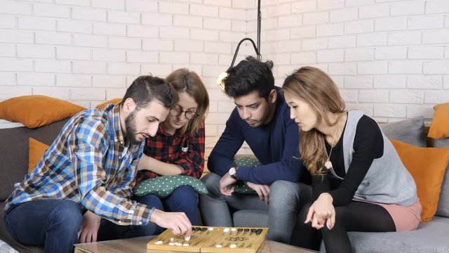 Caucasian man teaches his friends how to play backgammon 50 fps