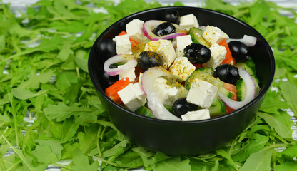 classic fresh beautiful delicious Greek salad with olives and feta cheese with fresh rucola  on a wooden background