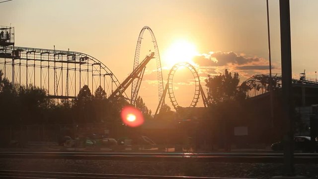 Wide, sunset over roller coaster loop