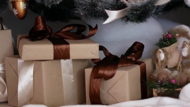 New Year gifts under the Christmas tree. Posting Christmas ornaments
