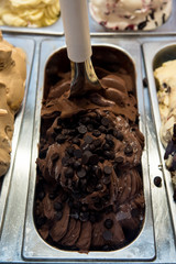 Creamy italian ice-cream in shop window, displayed in metal tubes. Ice cream parlor 