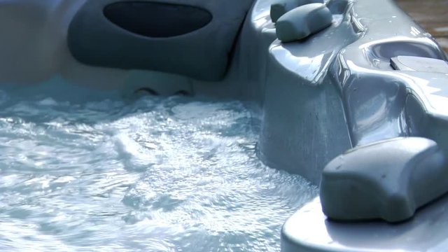 Close up, person steps into hot tub in slow motion