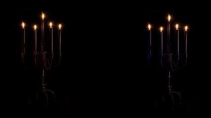 Close up, dueling candelabras burn