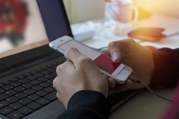 hands with mobile phone and computer on the desktop