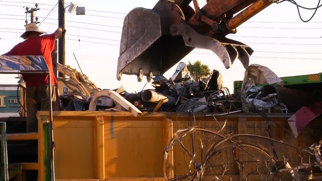 Crane digs out scrap pieces in dumpster