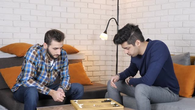 Turkish and Caucasian guys play backgammon 50 fps