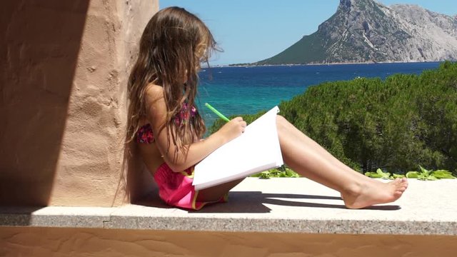 Little girl in a bath suit drawing a beautiful sea and island landscape in the summer, slowmo HD