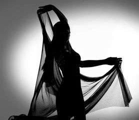 Silhouette of woman dancing with transparent fabric in black and white