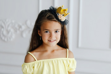 Long-haired little girl in yellow posing in the room © Vladimir