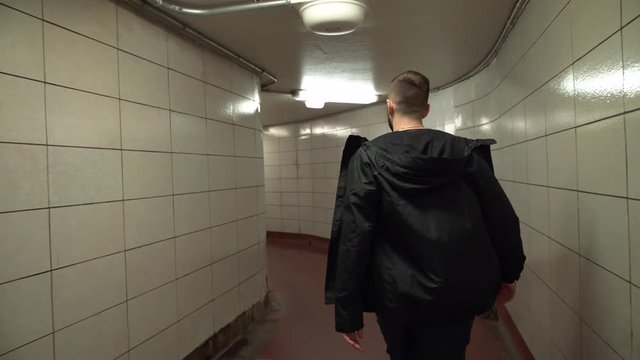 Man walking alone through a tunnel in the Chicago Underground.