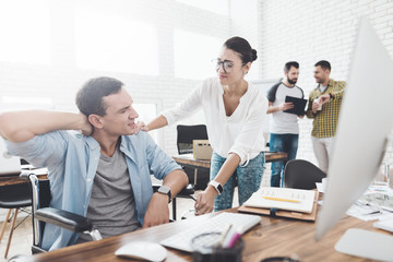 The girl is trying to help a man in a wheelchair. He feels pain in his neck.