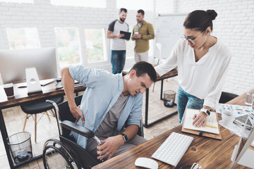 Fototapeta premium Dziewczyna próbuje pomóc mężczyźnie na wózku inwalidzkim. Czuje ból w plecach.