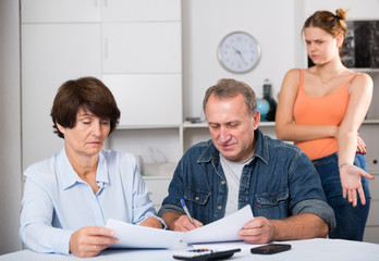 Fototapeta premium Adult couple is singing contract with their daughter