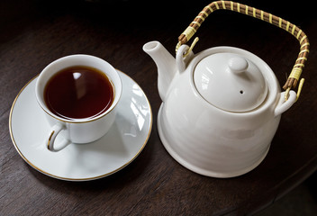 Cup of tea with teapot on a Wooden Table