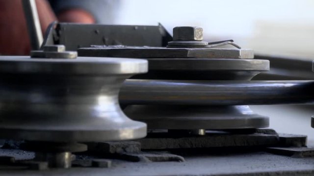 Slow-motion shooting, a man in working clothes working with a pipe bending machine