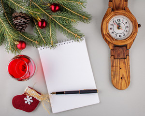 Empty sheet of paper, pen, a spruce branch and Christmas-tree toys on a light gray background. With copy space. Business desk table concept.
