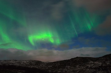 Night over the hills clouds and Aurora.