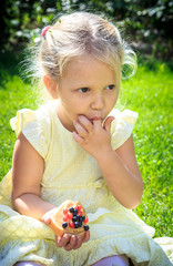 little blonde girl eats peanut butter by her finger