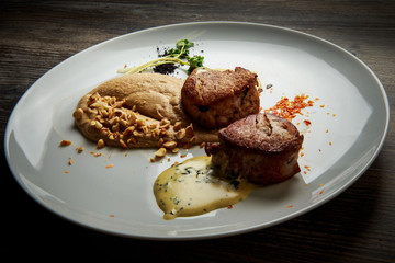 two tasty pieces of grilled meat with puree and sauce