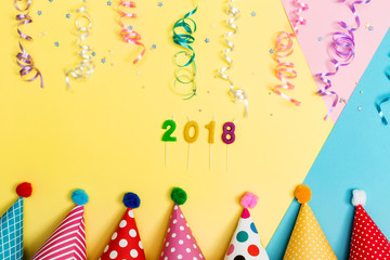 2018 party theme with with hats and streamers on a vibrant background