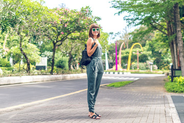 Closeup attractive beautiful woman with snakeskin python handbag posing outdoors. Bali island.