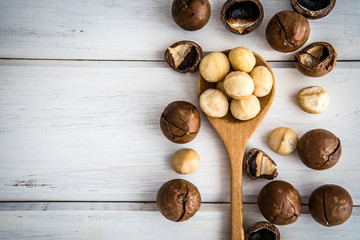 Close up Macadamia nuts on  white wooden background , the  superfood and healthy food concept , overhead or top view shot with vintage color tone