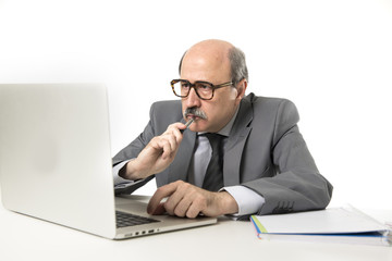 corporate portrait bald 60s serious and bossy business man thinking and working at computer laptop...