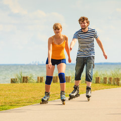 Young couple on roller skates riding outdoors
