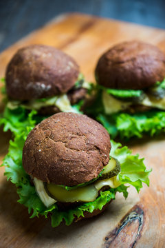 Burgers on the dark rustic background. Selective focus. Shallow depth of field. Black and white image.