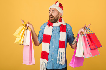 Christmas man shopper hold shopping bags on yellow background