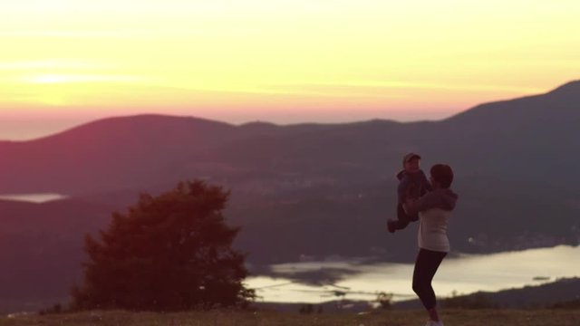 Boy running to his moter at the sunset in mountains