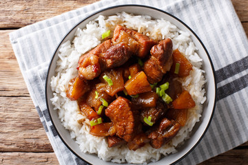 Philippine cuisine: Hamonado pork with pineapple and garnish of rice close-up. horizontal top view