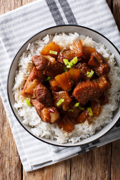 Philippine cuisine: Hamonado pork with pineapple and garnish of rice close-up. Vertical top view