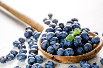 Wooden spoon with blueberries isolated on white background