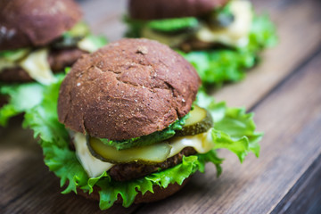 Burgers on the dark rustic background. Selective focus. Shallow depth of field. Black and white image.