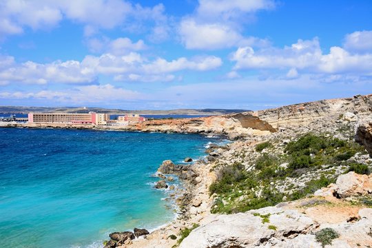 Rocky coastline with hotels to the rear, Paradise Bay, Malta.